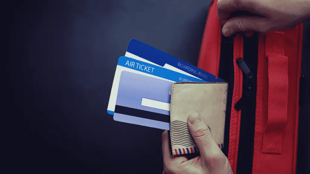 Human hand putting travel documents in a purse